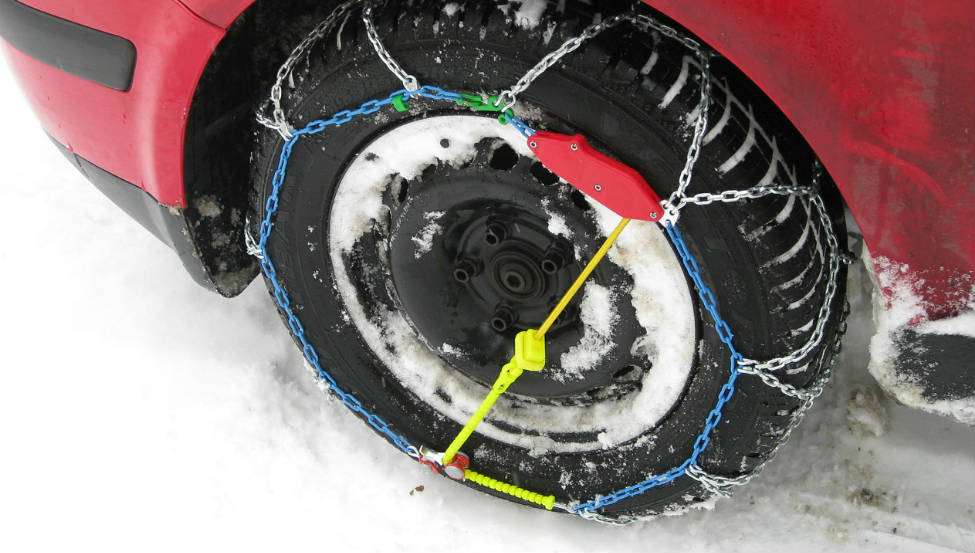Cdenas de nieve colocadas en la rueda de un coche