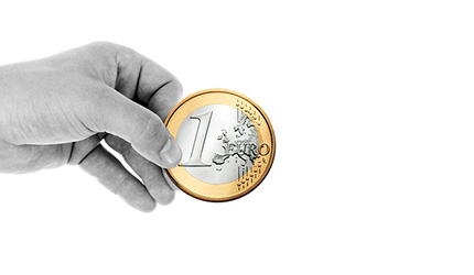 Una mano sujeta una moneda de euro