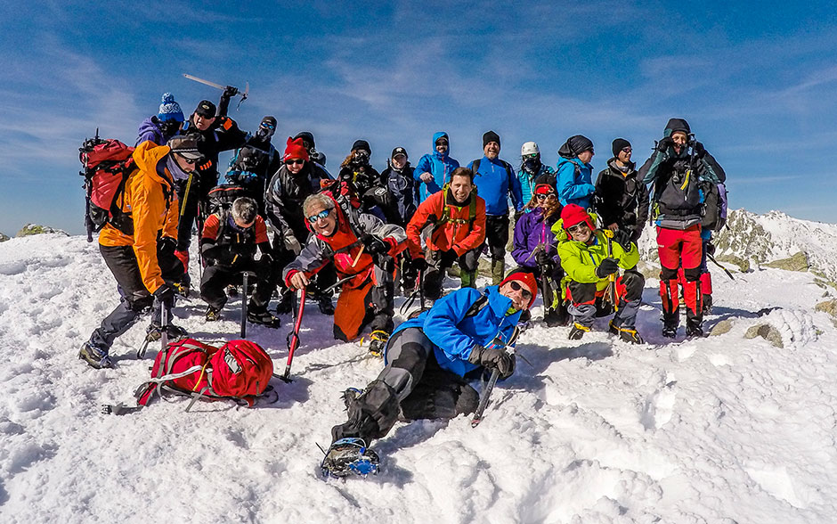 Un grupo de personas sobre la cima de un pico nevado