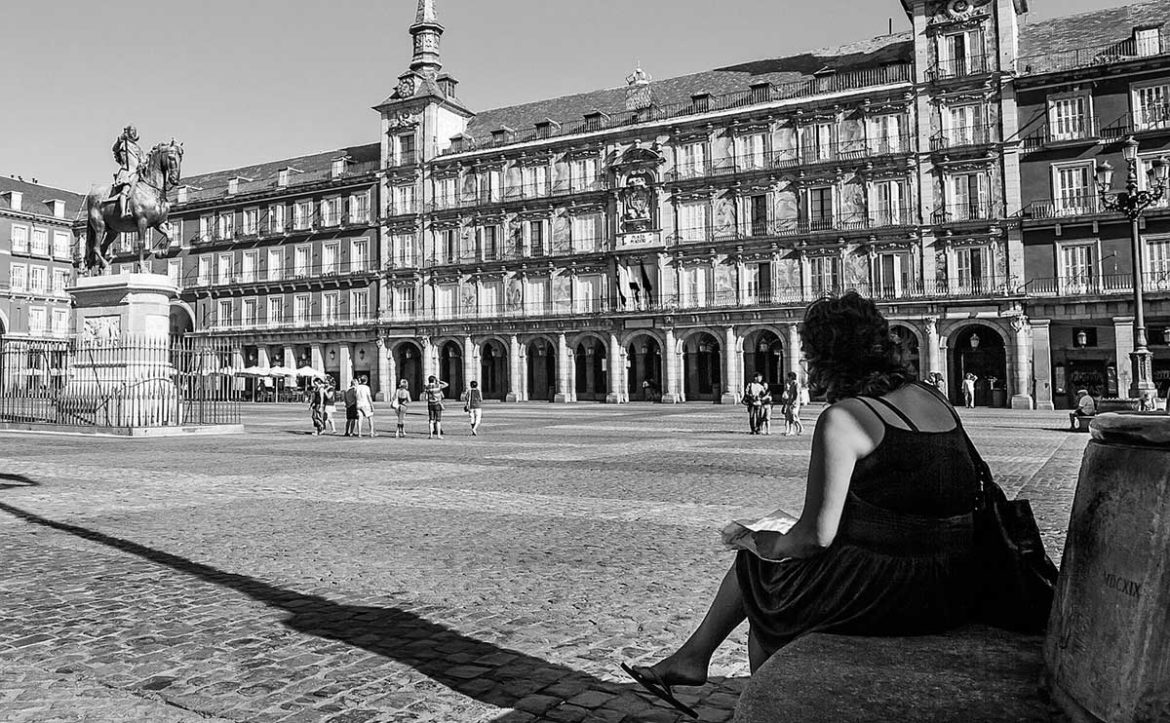 Una mujer sentada en la Plaza Mayor de Madrid