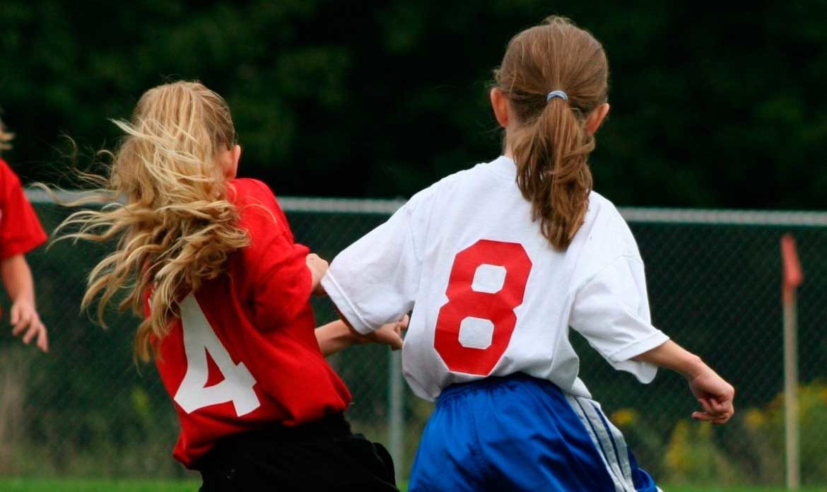 Dos niñas, de espaldas, jugando al fútbol