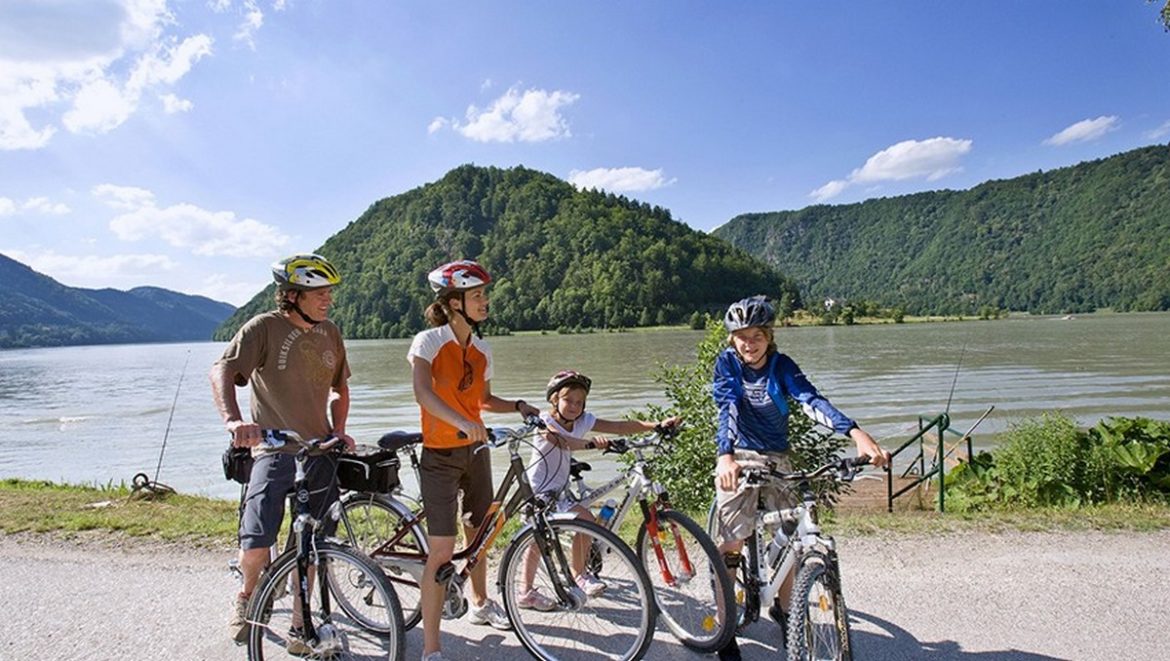 Una familia con sus bicicletas junto a un lago