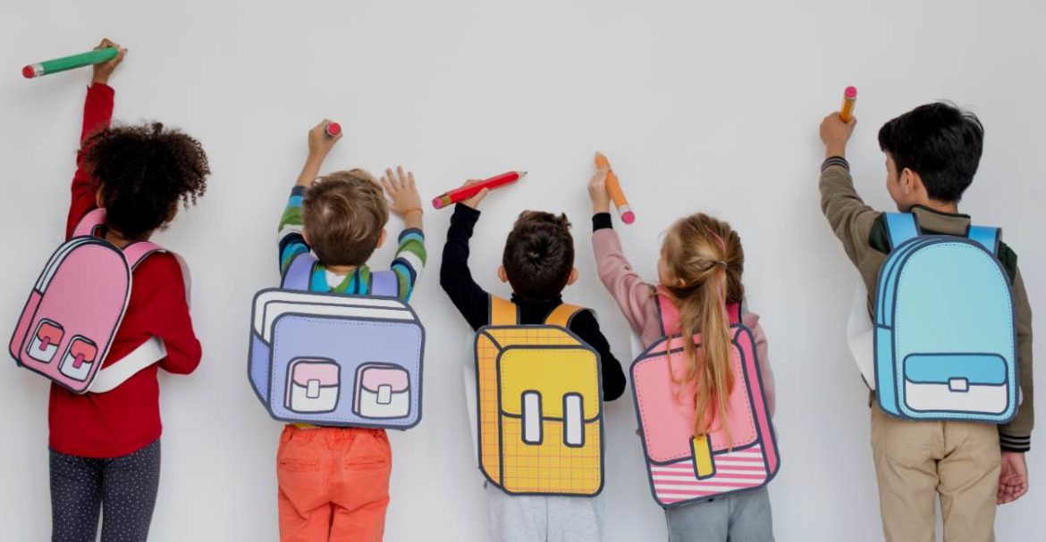 Niños con carteras dibujadas en sus espaldas pintando en la pared