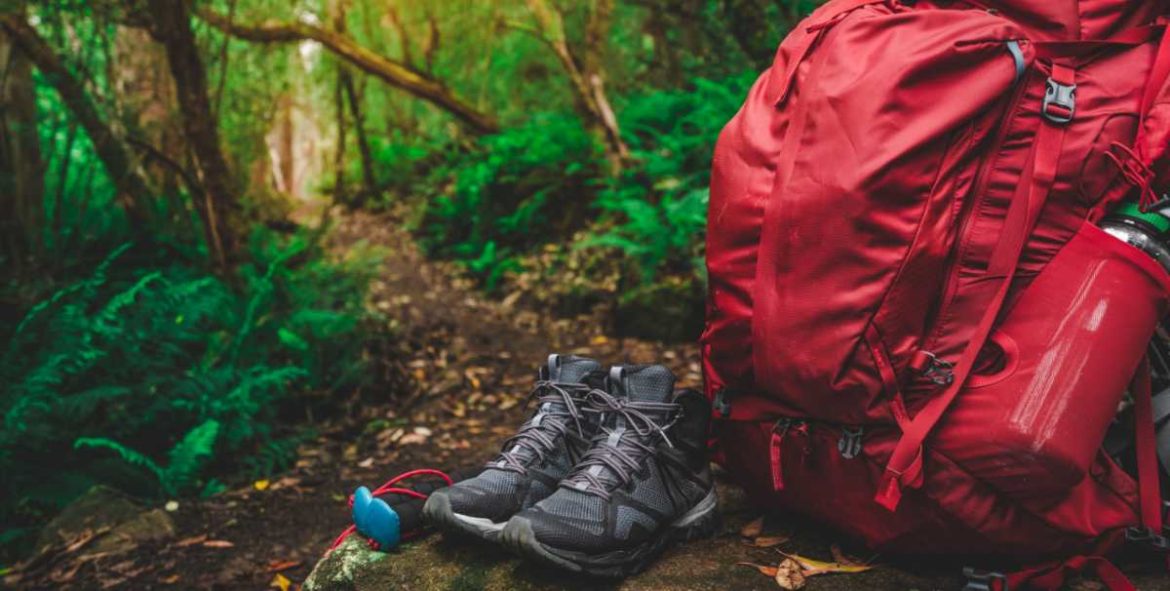 Mochila y botas de montaña en un bosque