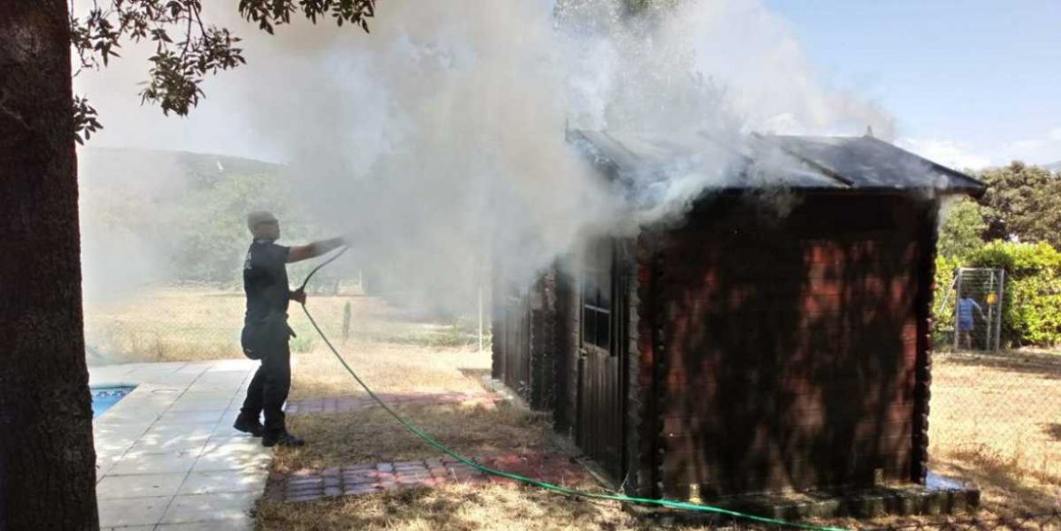 Un agente de la policía local de Moralzarzal sofoca un incendio