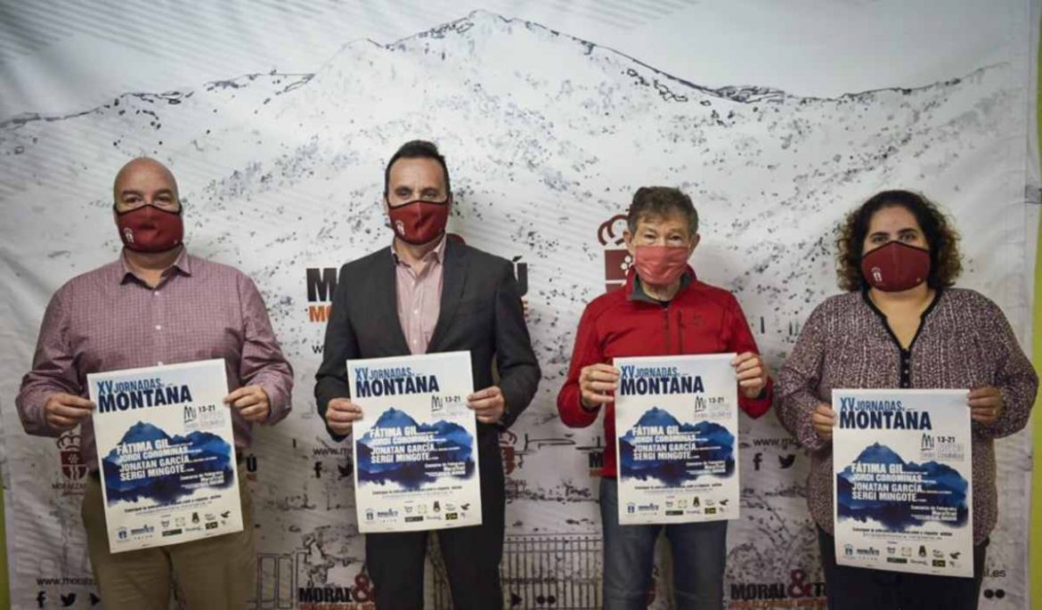 Carlos Soria con el alcalde de Moralzarzal y dos concejales sostienen el cartel de las jornadas de montaña