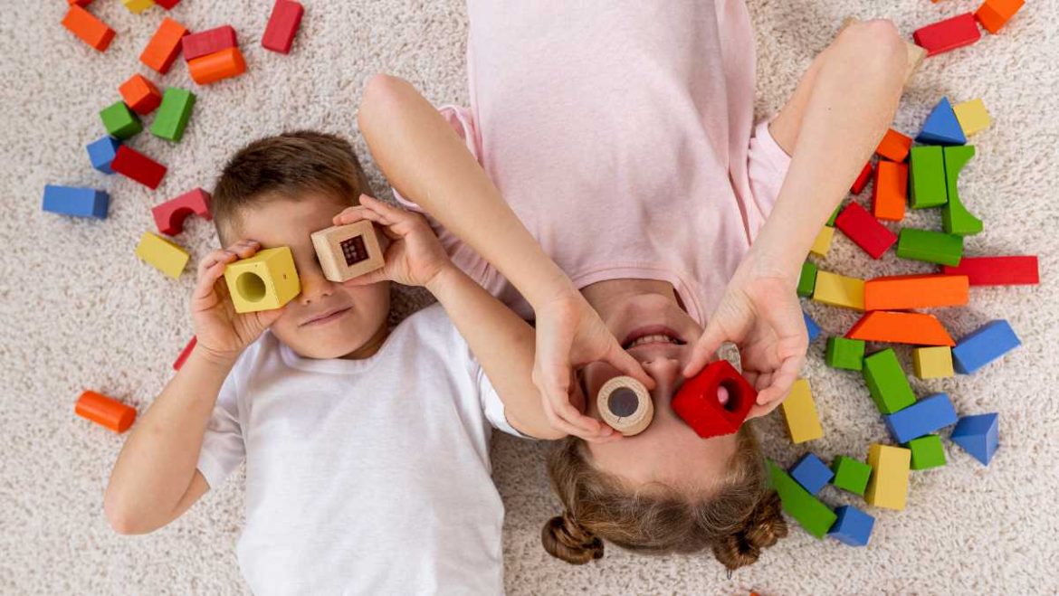 Un niño y una niña jugando con piezas de colores