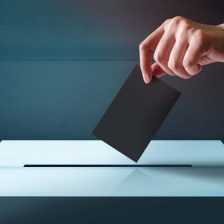 Una mano introduce un voto en una urna