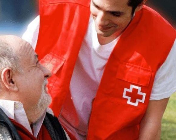 Un voluntario de Cruz Roja ayuda a un mayor