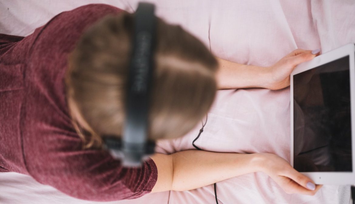 Una chica con una tablet tumbada en la cama