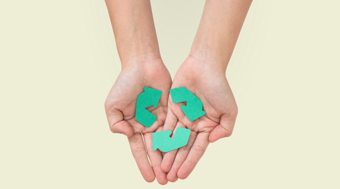 Unas manos sostienen el símbolo del reciclaje